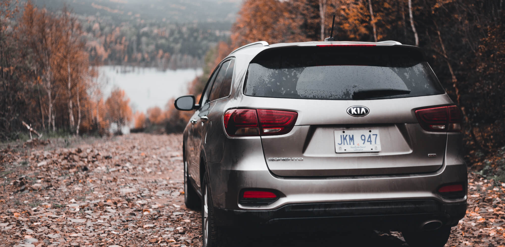 Kia car parked near autumn lake 
